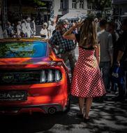 girl in a polka dot dress at the mustang car