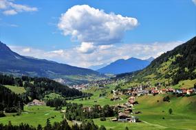 distant panorama of alpine meadows and alpine village in Switzerland