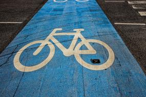 White bike sign on the blue cycle path