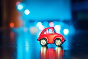 red toy car on a background of night lights