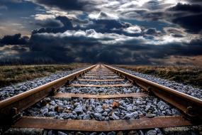 crushed stone on railway tracks against a cloudy sky