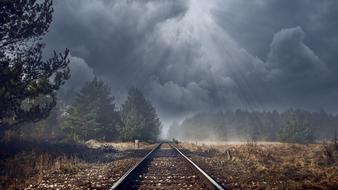 stormy sky and the rays of the sun over the railway