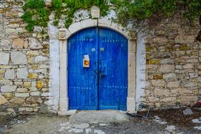 blue gate in a stone building in the village