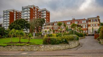 Colorful buildings, among the colorful and beautiful plants, in Bournemouth, England, UK, under the cloudy sky