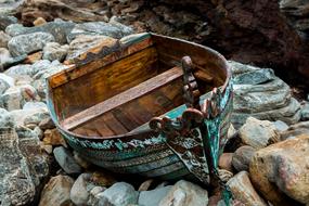 painted old wooden Boat on stones