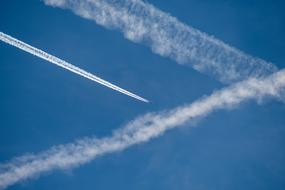 white path from plane in blue sky