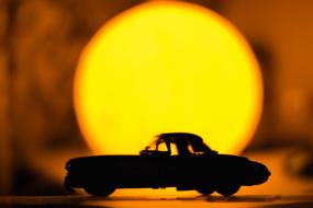 Silhouette of the model of the vintage car, at colorful Sun light, at background
