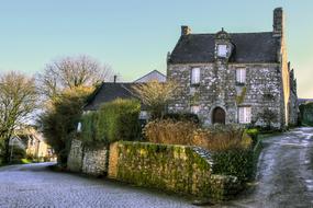 Beautiful landscape of the house and colorful plants, in snow, in Locronan, Brittany, France