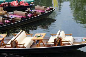 Colorful boats on the green water, with ripple and reflections