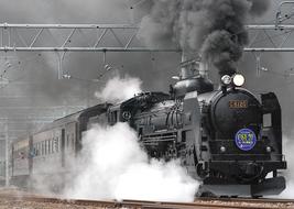 steam locomotive speeding in clouds of smoke, Japan