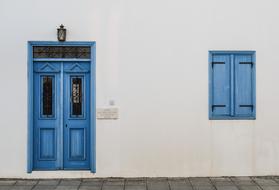 blue windows and doors on a white facade in cyprus