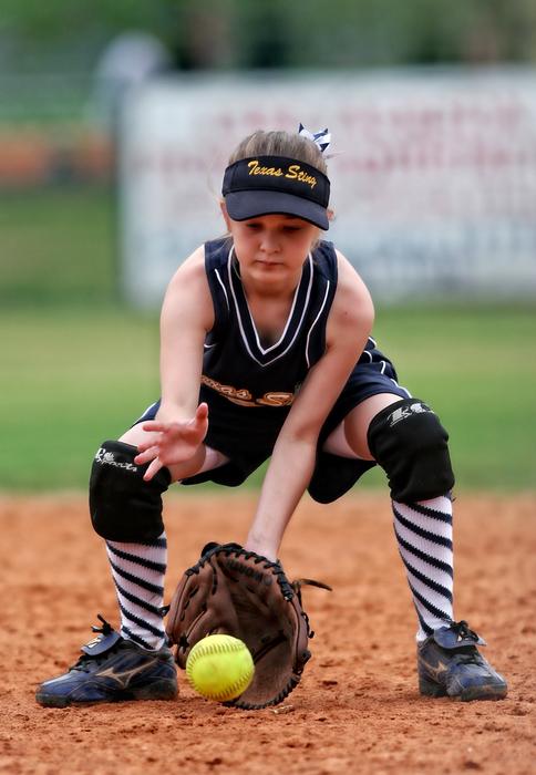 softball player is catching the ball