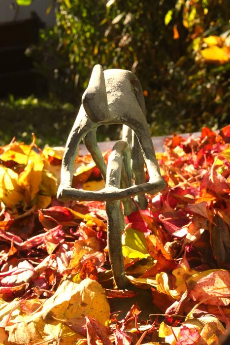 sculpture of a cyclist among the autumn foliage