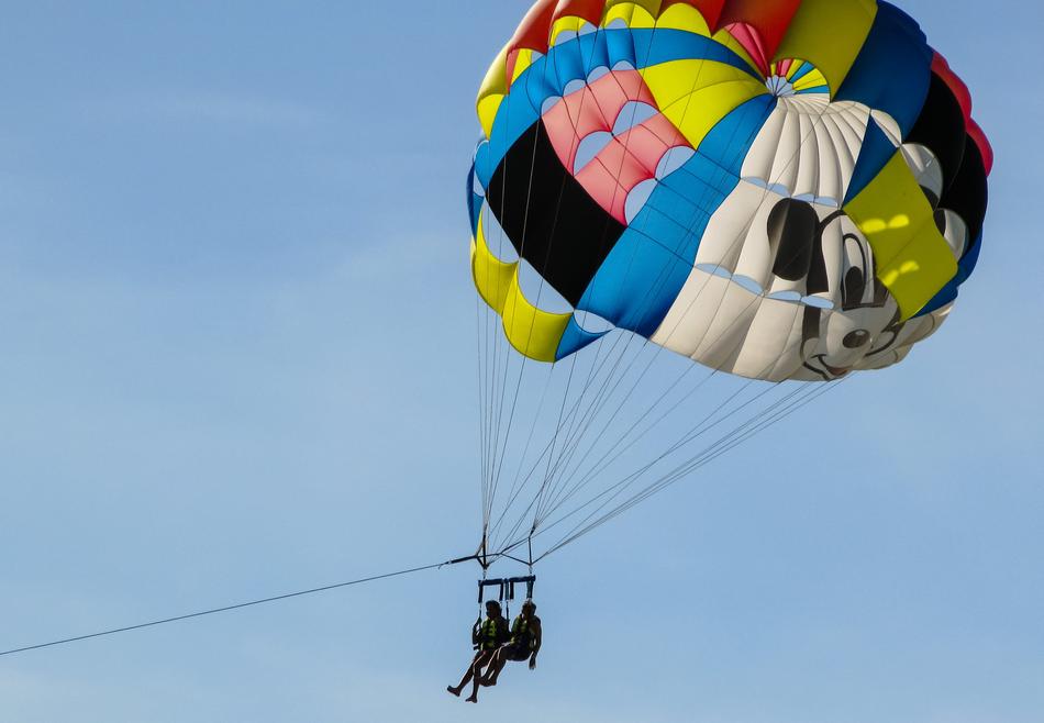 multicolored parachute high in the blue sky
