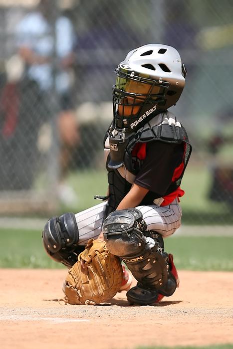 baseball catcher sits at the base