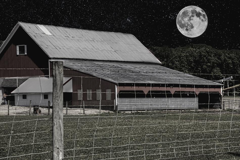 barn behind the fence under the moonlight at night