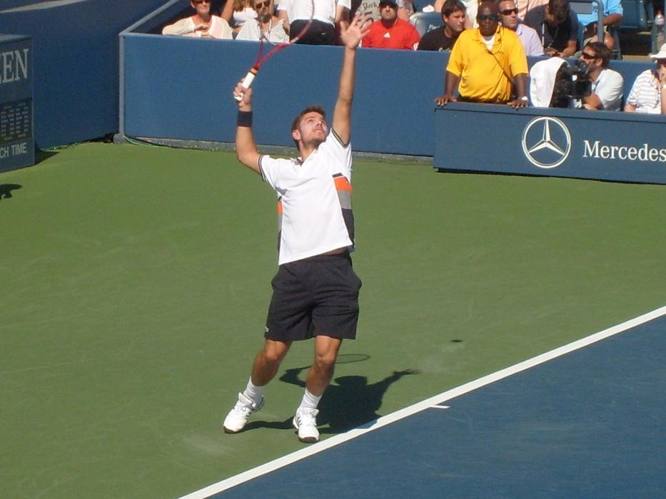 Stanislas Wawrinka, playing tennis, on the green, blue and white court, in 2010