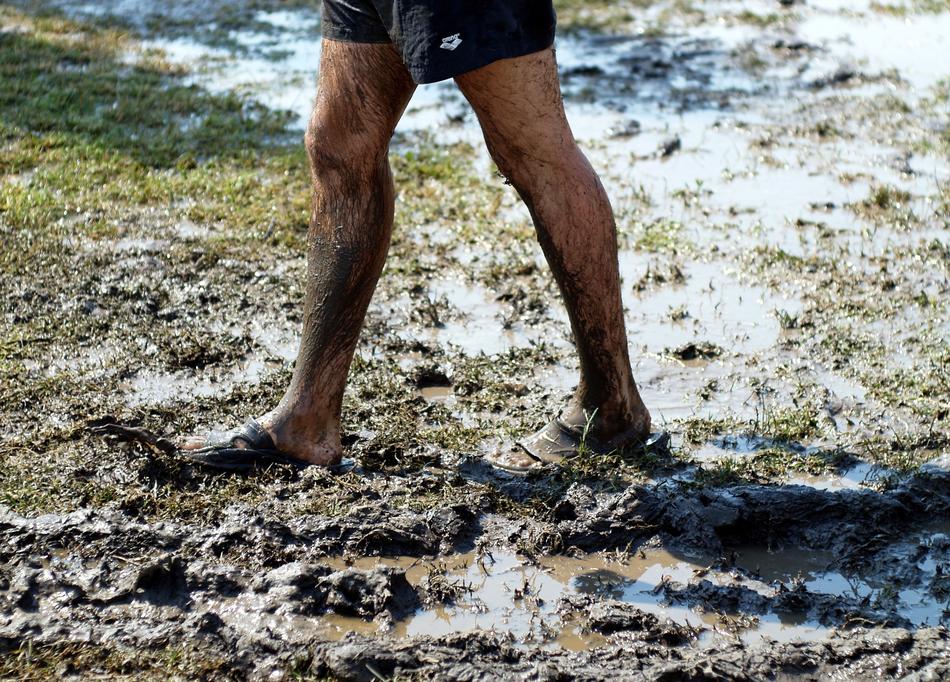 Person, standing in the wet mud, with the colorful grass, in light