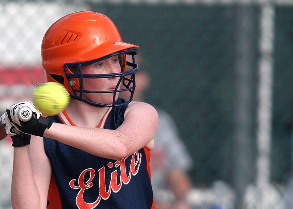 ball in front of Female Softball player, Batter