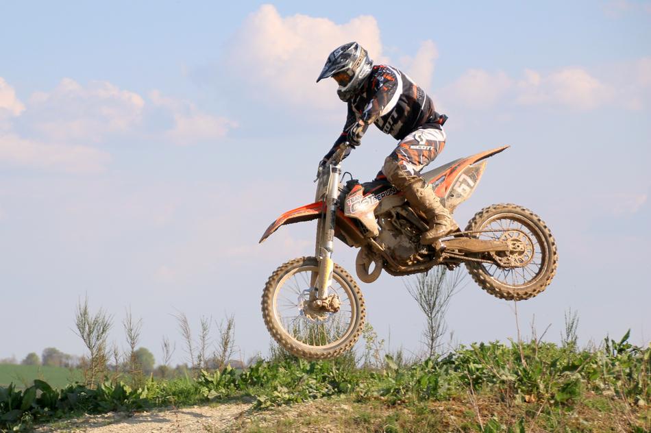 motorcyclist jumping in the meadow during the race
