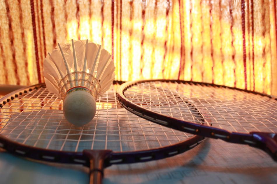 Badminton shuttlecock on the racquets, in the beautiful and colorful light