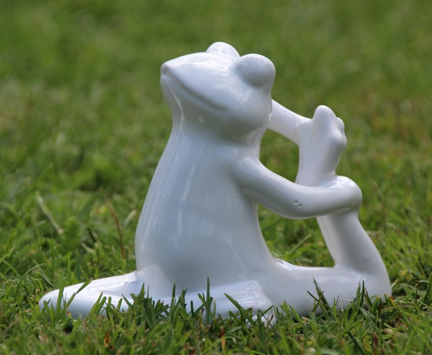 plaster frog sculpture on green grass