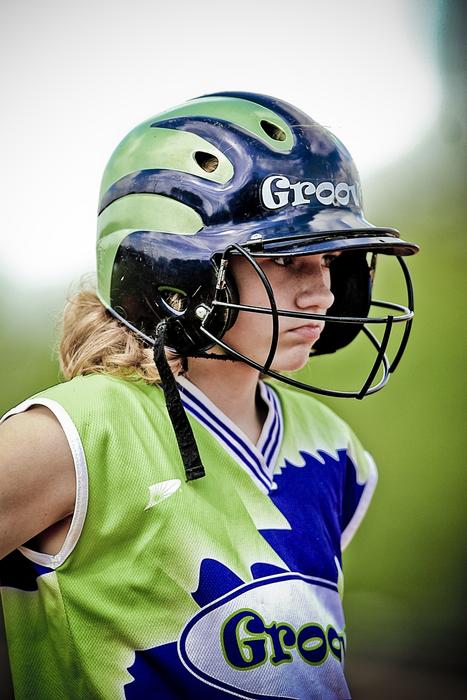 portrait of a softball player in defense on a blurred background