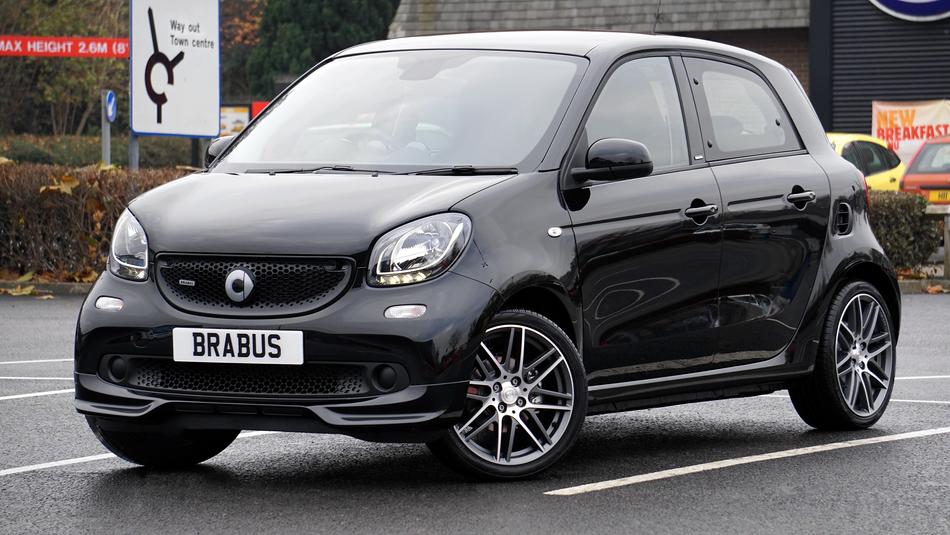 Shiny, black car with the 'Brabus' sign, on the road, near the colorful cars