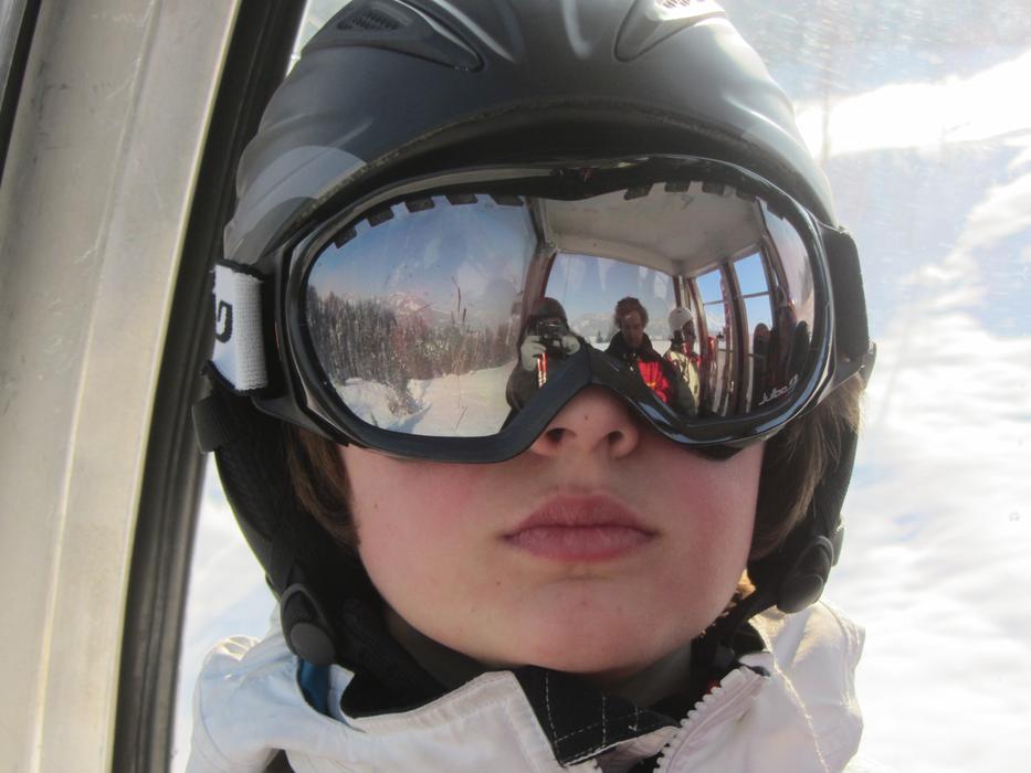Portrait of a child with the helmet for wintersport, with the reflection, among the beautiful, white snow