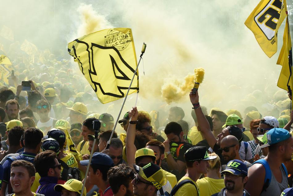 People with yellow, black and white flags, on the Misano in 2016