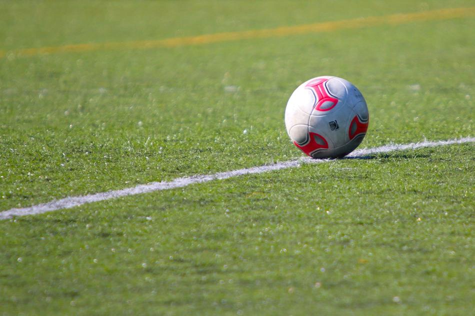 Colorful football, on the green field with colorful lines