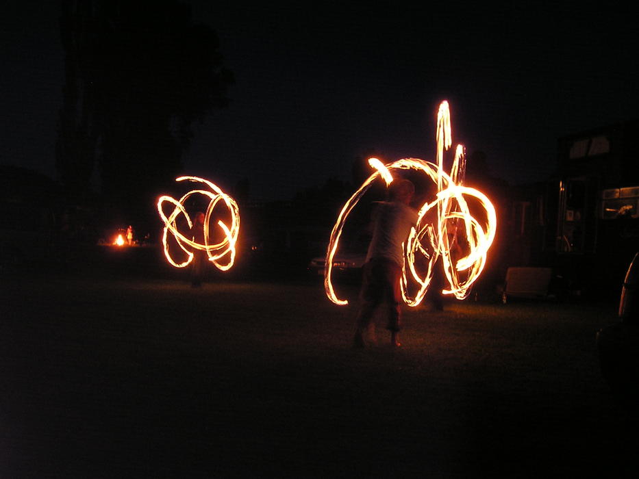 Acrobats, doing beautiful fire dancing, among the darkness