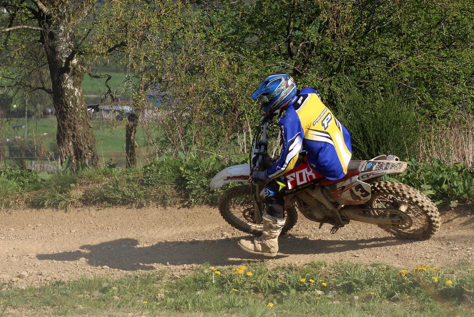Person, riding on the motorcycle on the path, among the beautiful and colorful plants with the flowers