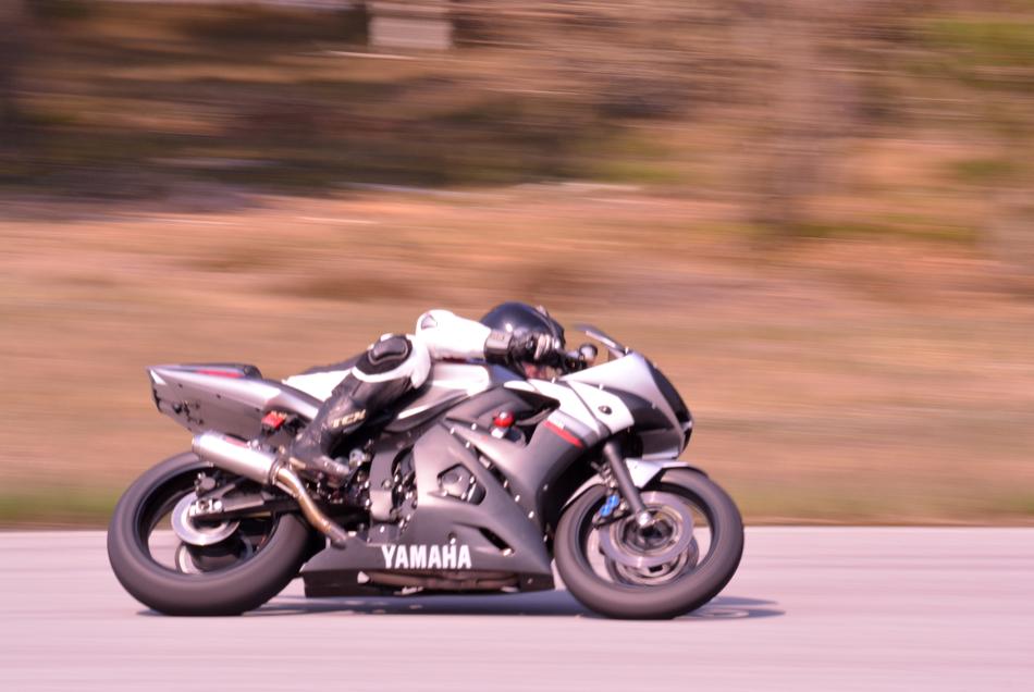 Biker on the road, in motion, among the colorful fields