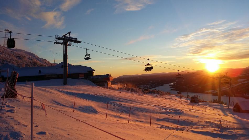 photo of the cable car at a ski resort against the backdrop of a bright sunset