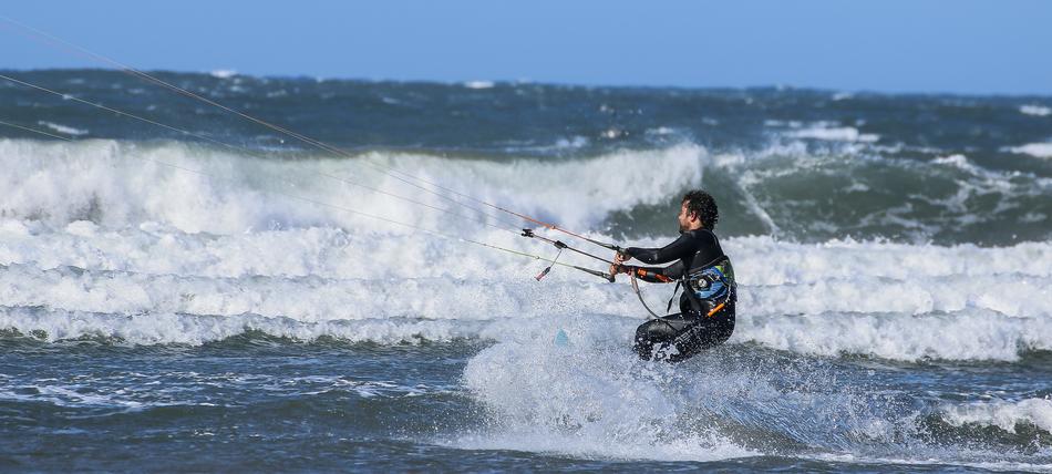 the athlete rides the waves on kitesurfing