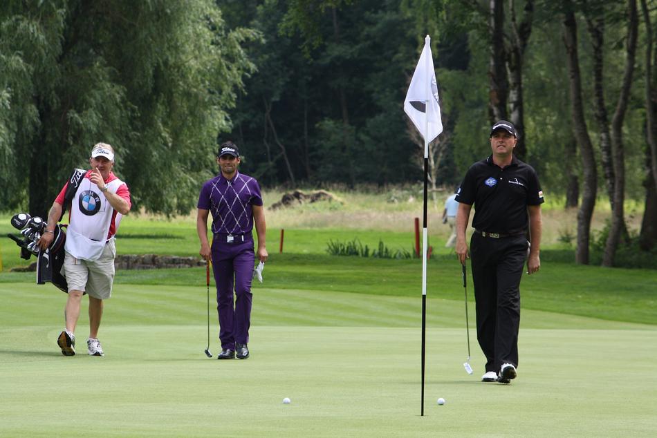 Lee Slattery and Graeme Storm playing golf on the green meadow, among the green trees