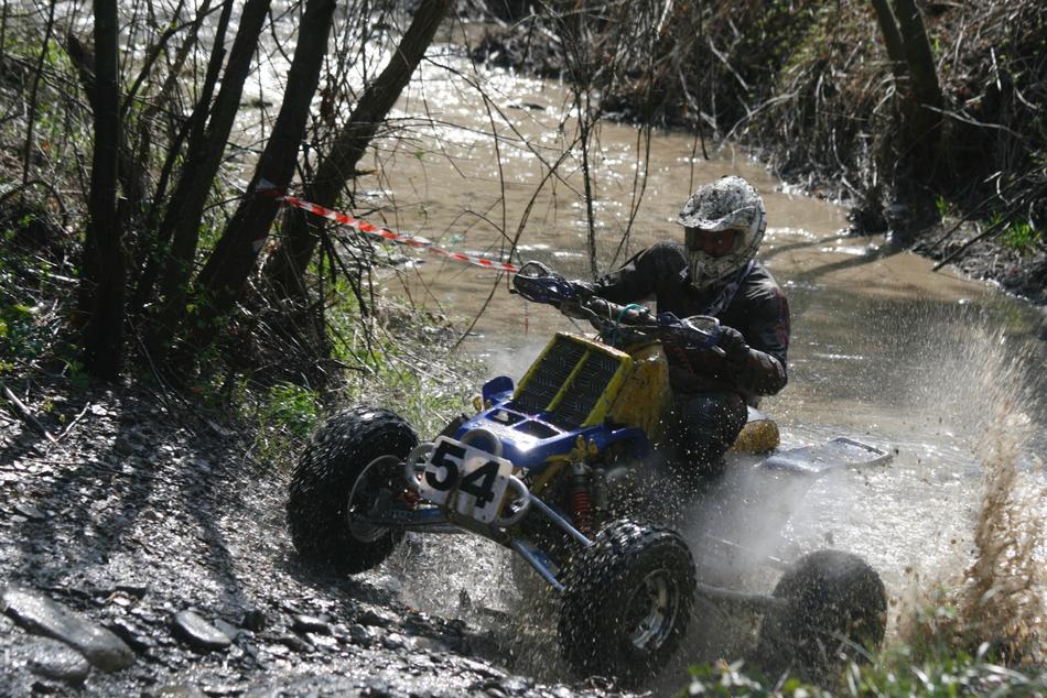Person, riding on the 'Yamaha Banshee' quad, near the water, among the colorful plants