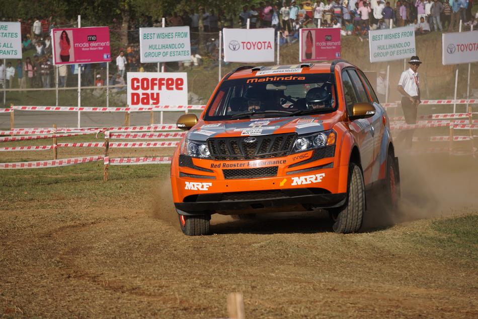 Shiny rally car on the race with spectators, in Chikmagalur, India