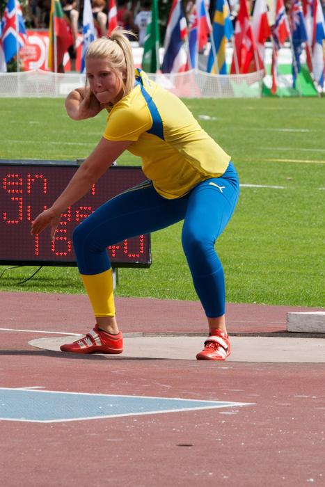 Woman on the shot put competition with spectators