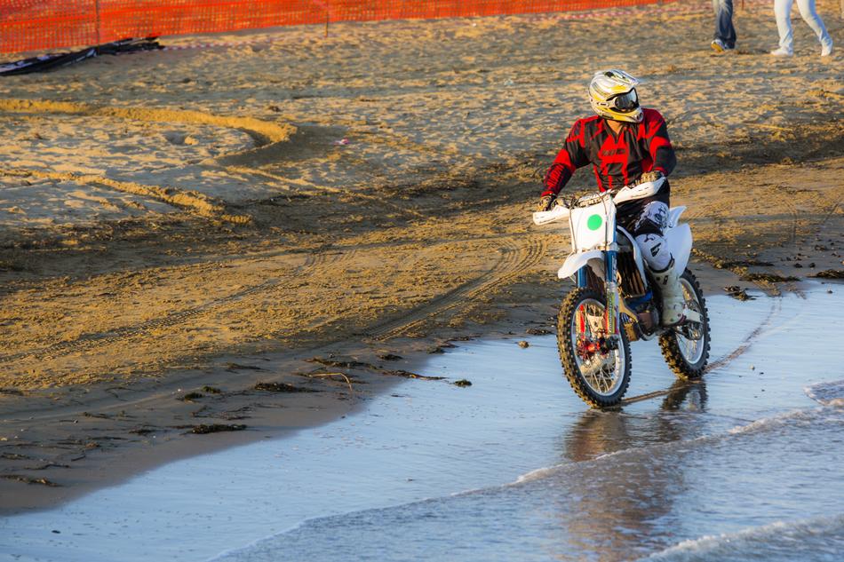 boy riding Motorcycle on beach at water