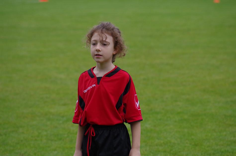 Cricketer girl player on the green grass field