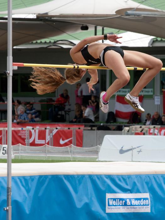 girl jumping over the bar in athletics