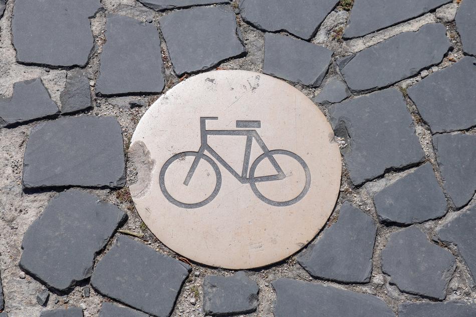 Bike sign on the circle, among the pavement on the street