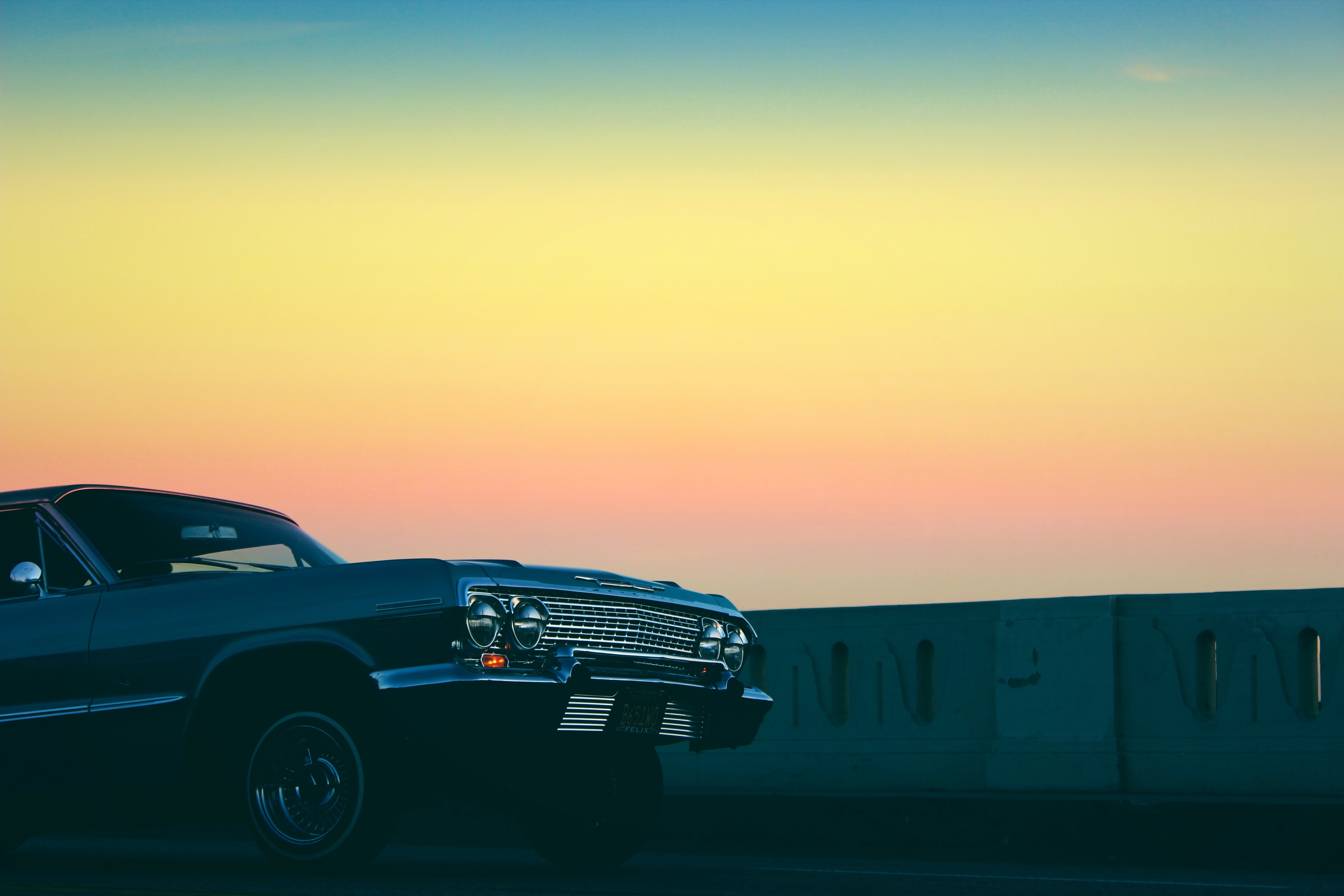 Beautiful, shiny, vintage car, at colorful, gradient sunset in the sky