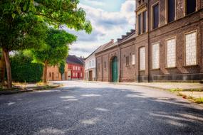 Beautiful landscape of the road, among the green trees and colorful houses in light, in Immerath, Germany
