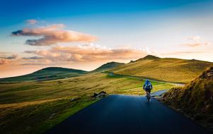 person Cycling away in scenic wilderness at dusk on the landscape , Romania