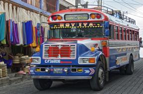 bright painted oldtimer Bus at street market, guatemala