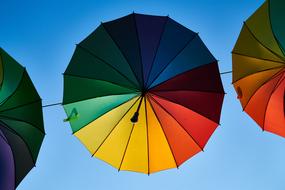 Bottom view of the colorful and beautiful, flying umbrellas, at blue sky on background