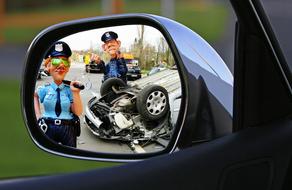 car accident and police figures in the reflection of a car mirror